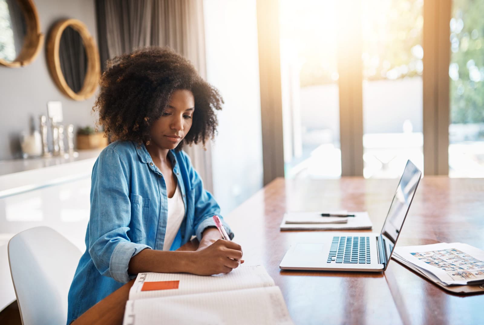 A researcher making notes at a laptop